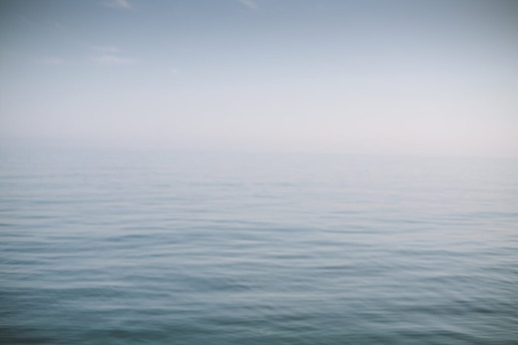 Vast ocean view with gentle waves and a clear, calm sky. Perfect for tranquility and nature themes.