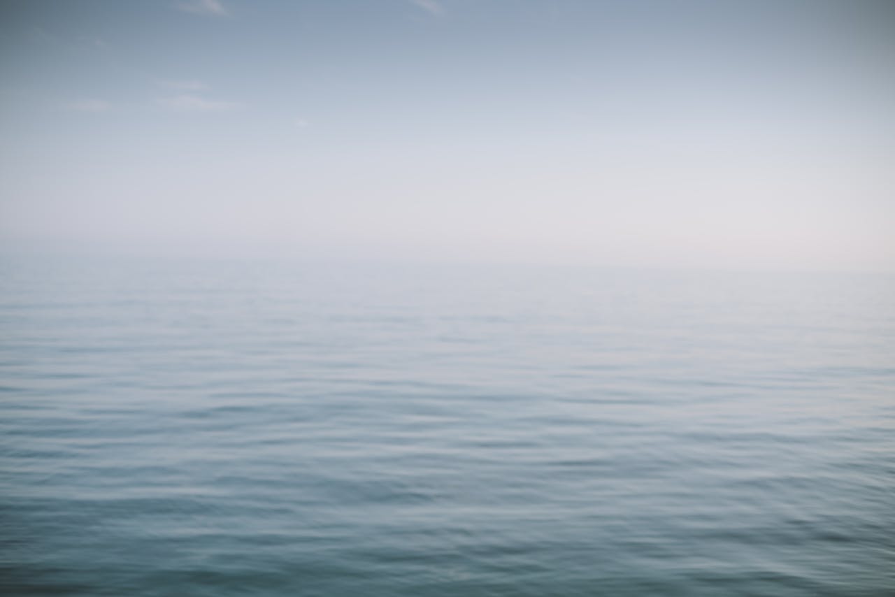 Vast ocean view with gentle waves and a clear, calm sky. Perfect for tranquility and nature themes.